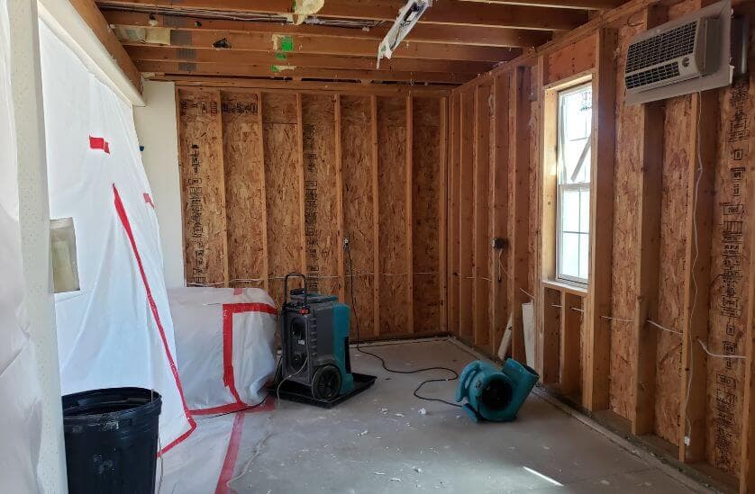 Drywall removed during mold remediation with containment and drying equipment
